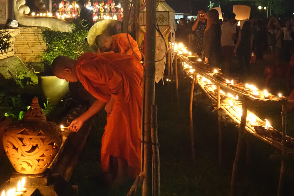 Buddhistische Moenche zuenden Kerzen an