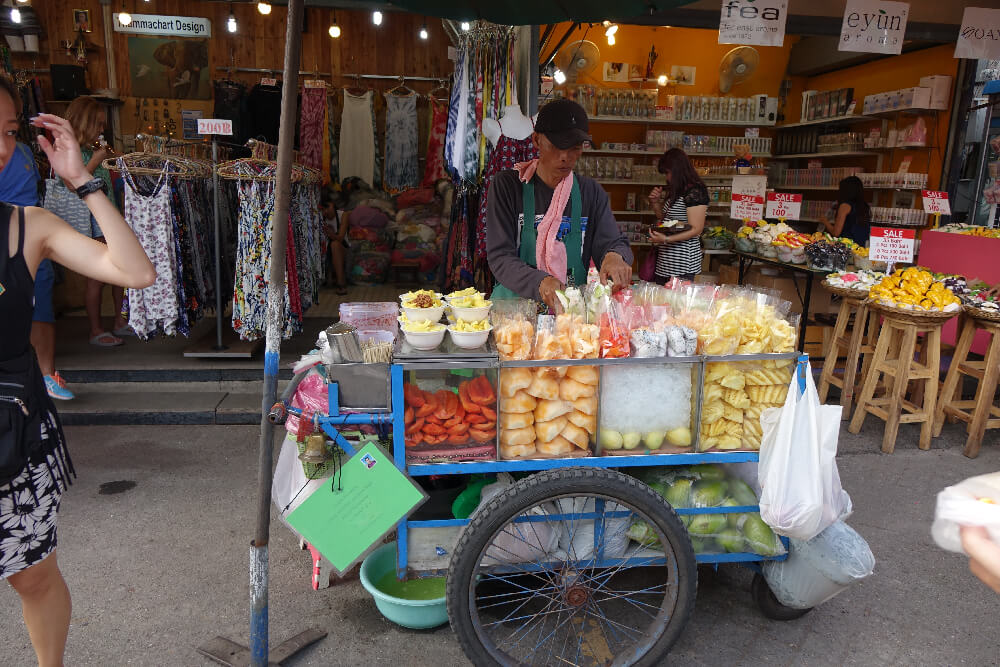 Streetfood Verkaeufer in Bangkok mit seinem Obststand